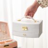 Boîte à bijoux avec rangement à plusieurs niveaux, miroir et serrure pour des accessoires bien organisés