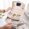Boîte à bijoux avec rangement à plusieurs niveaux, miroir et serrure pour des accessoires bien organisés